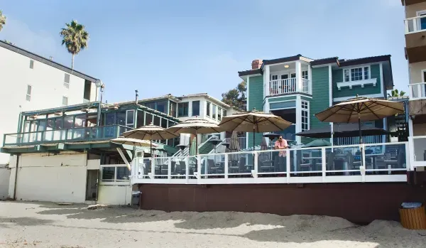 A large house with a balcony and umbrellas on Laguna Beach