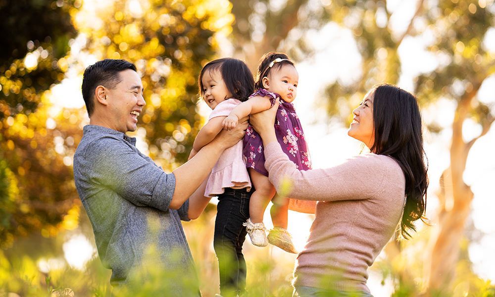 A family is posing for a picture in a park.