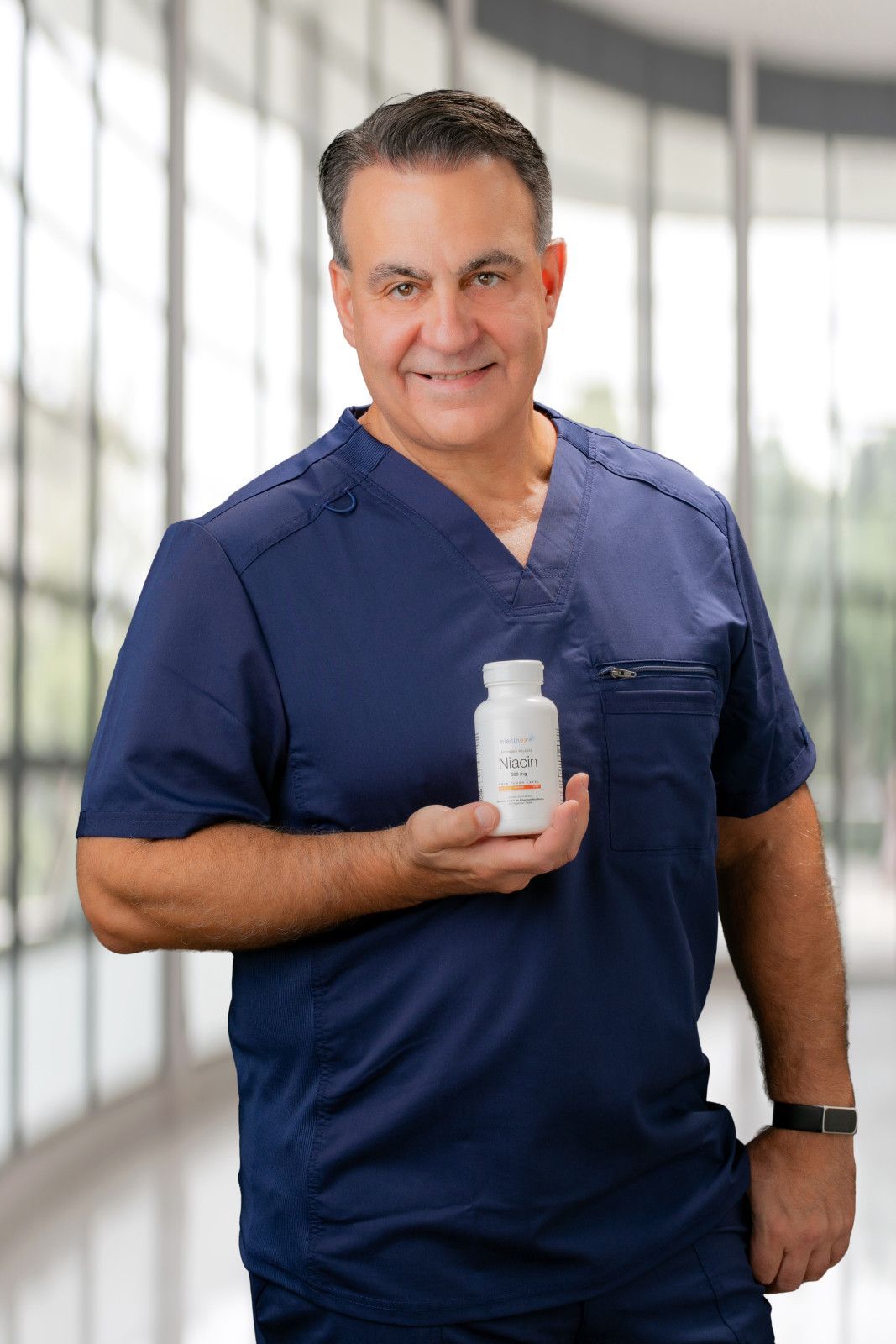 Medical professional in navy scrubs holding a white bottle in a bright clinic setting in Newport Beach, CA 