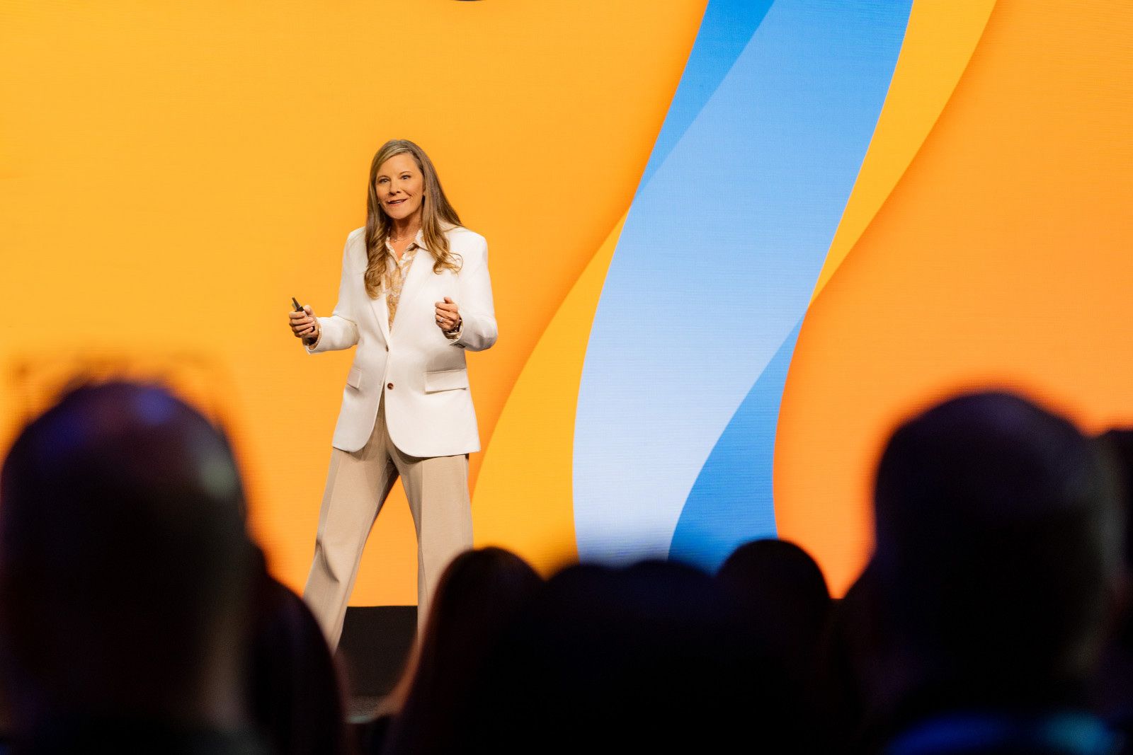 Keynote speaker wearing a white blazer standing on stage at a technology convention in Anaheim,ca
