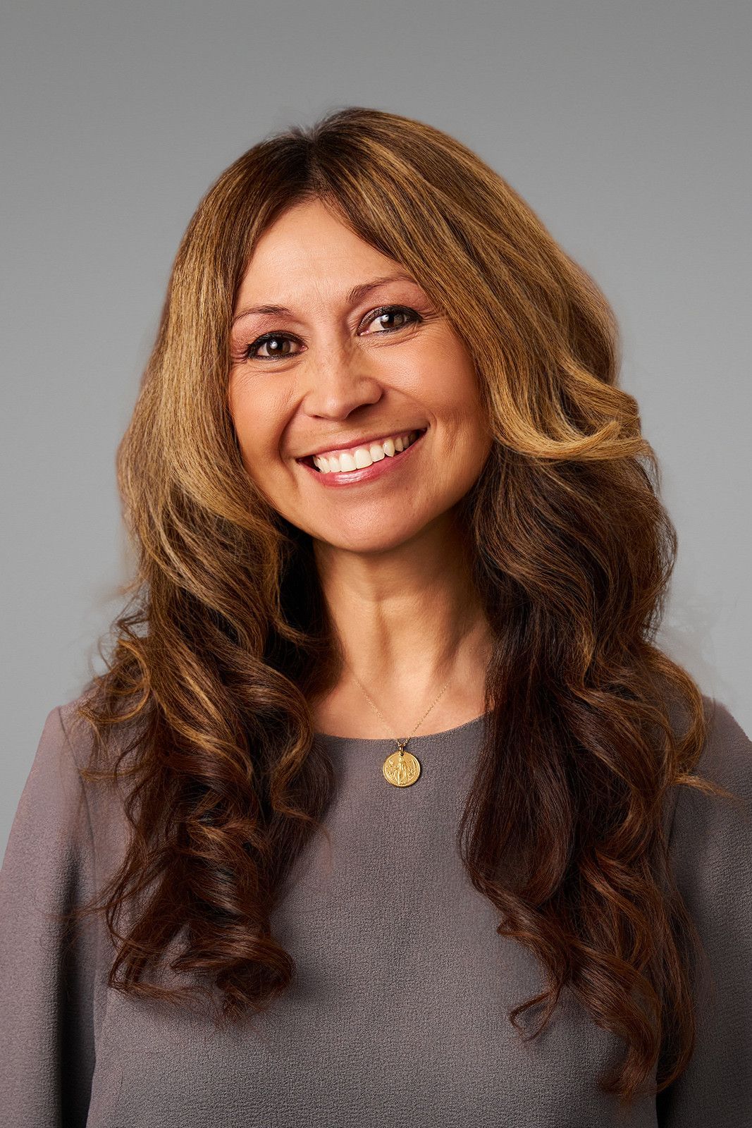 Hr headshots for UCI of a female employee against a gray backdrop.