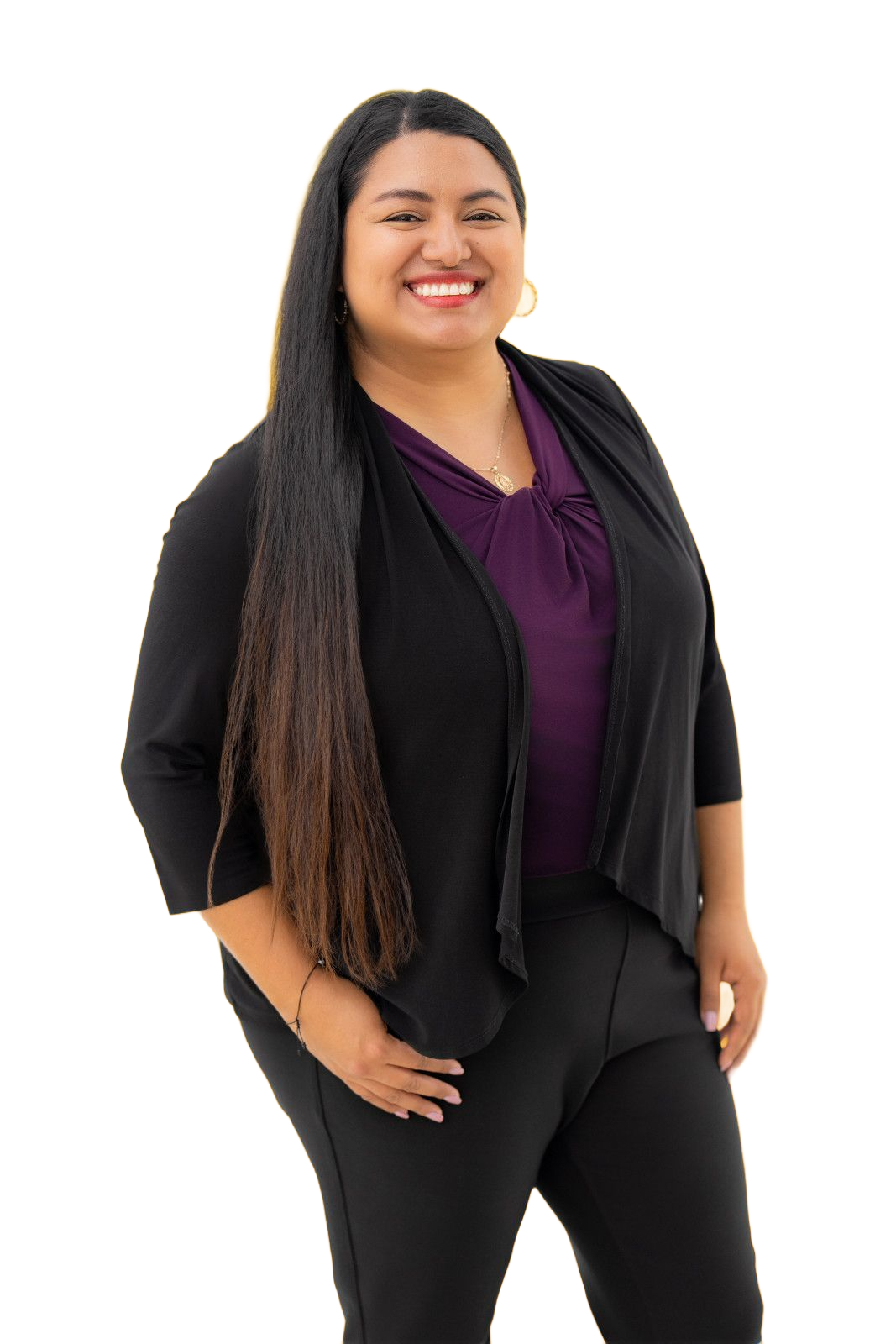 attorney headshot orange county A smiling person with long dark hair wears a purple top under a black cardigan and black pants against a white background.