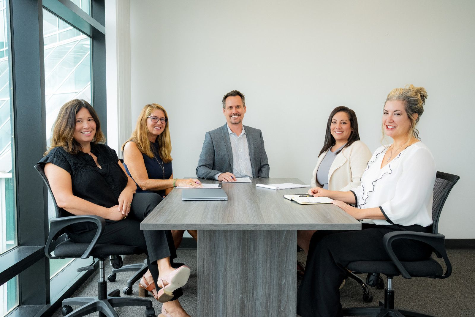 Financial Advisor Headshots Orange County Five coworkers are seated around a conference table in a bright meeting room professional headshots, Orange County CA,