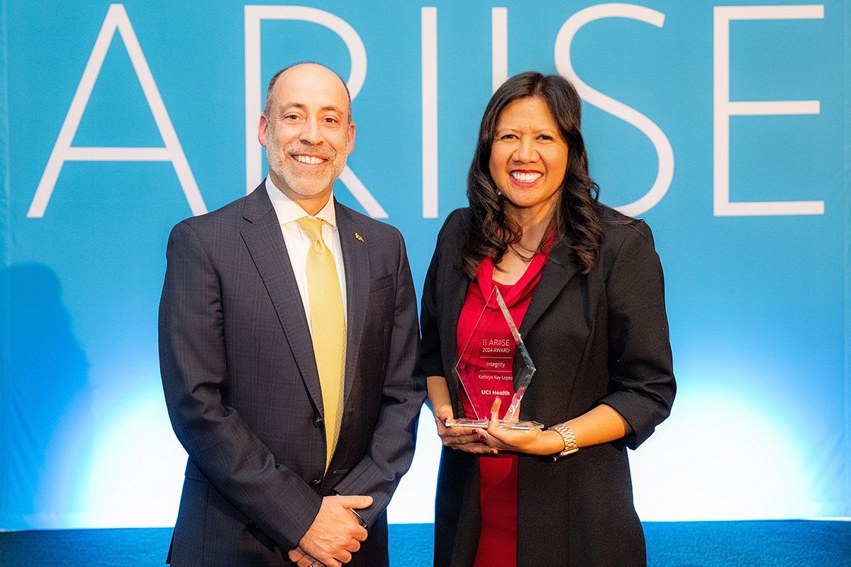 Corporate Event Awards Ceremony A man and a woman standing in front of a sign that says arise