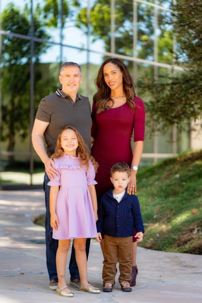 A family is posing for a picture in front of a building.