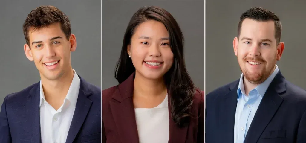 A man , a woman , and a man in a suit are posing for a picture.