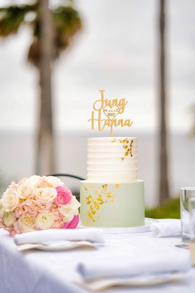A wedding cake is sitting on a table next to a bouquet of flowers.