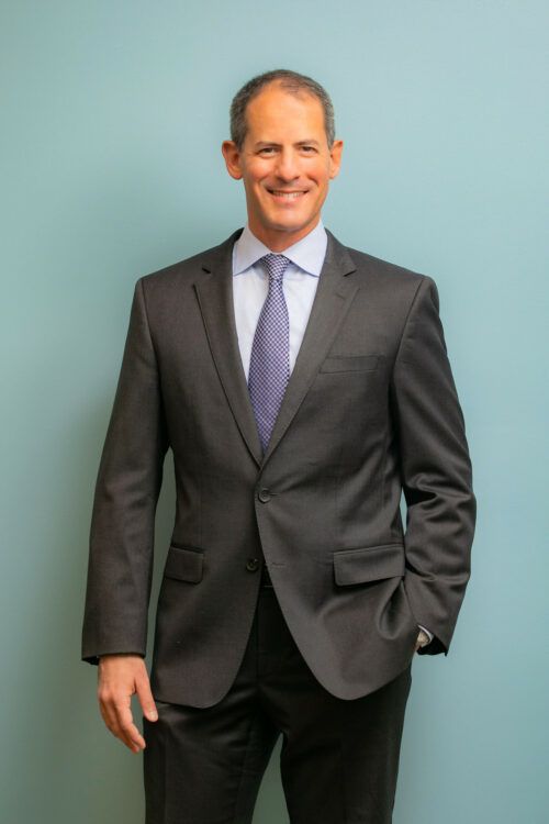 headshot tips mens hairstyles A man in a suit and tie is smiling for the camera.