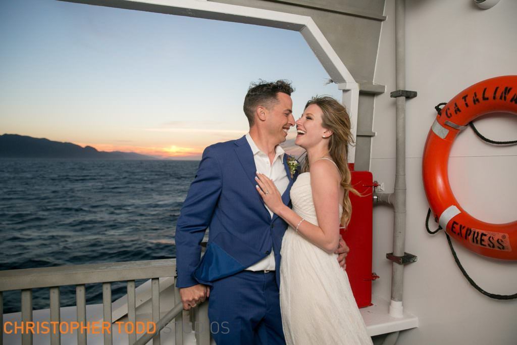 A bride and groom are posing for a picture on a boat to Catalina from Newport Beach.