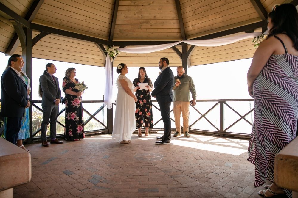 A bride and groom are getting married in a gazebo overlooking main beach in Laguna.