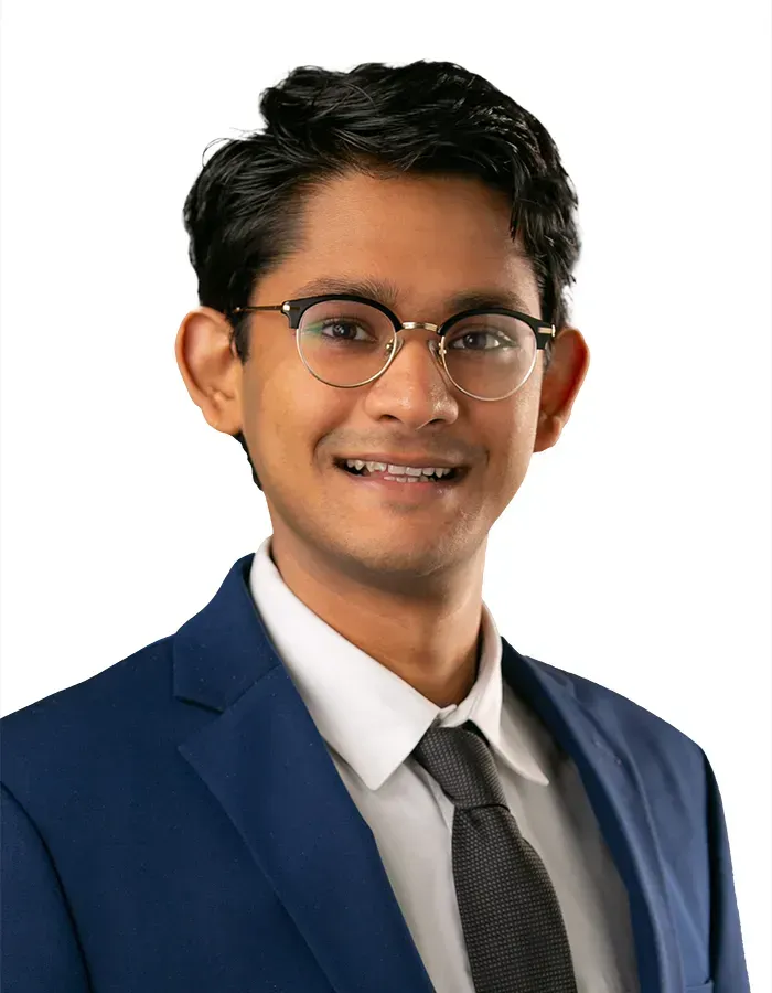 A man in a suit and tie is smiling for the camera