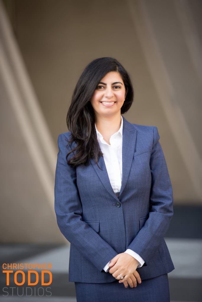 A woman in a blue suit and white shirt is posing for a picture.