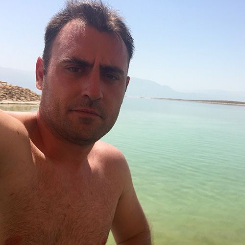 A shirtless man is taking an unappealing selfie that won't work on dating apps