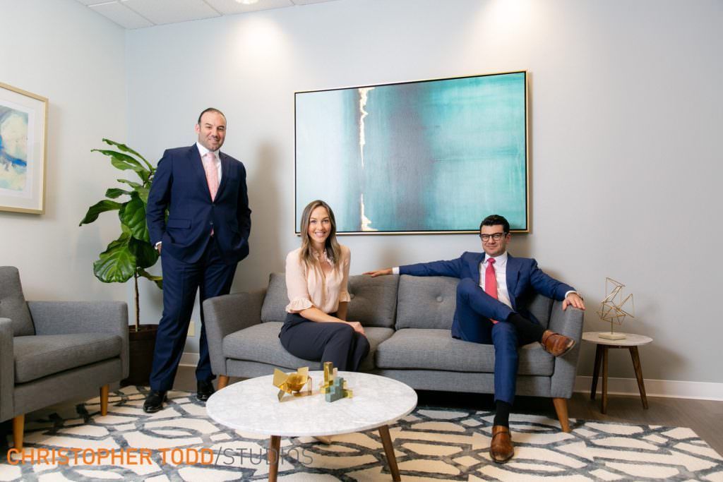Attorney Brand Photography A group of attorneys are posing for a picture in a living room.