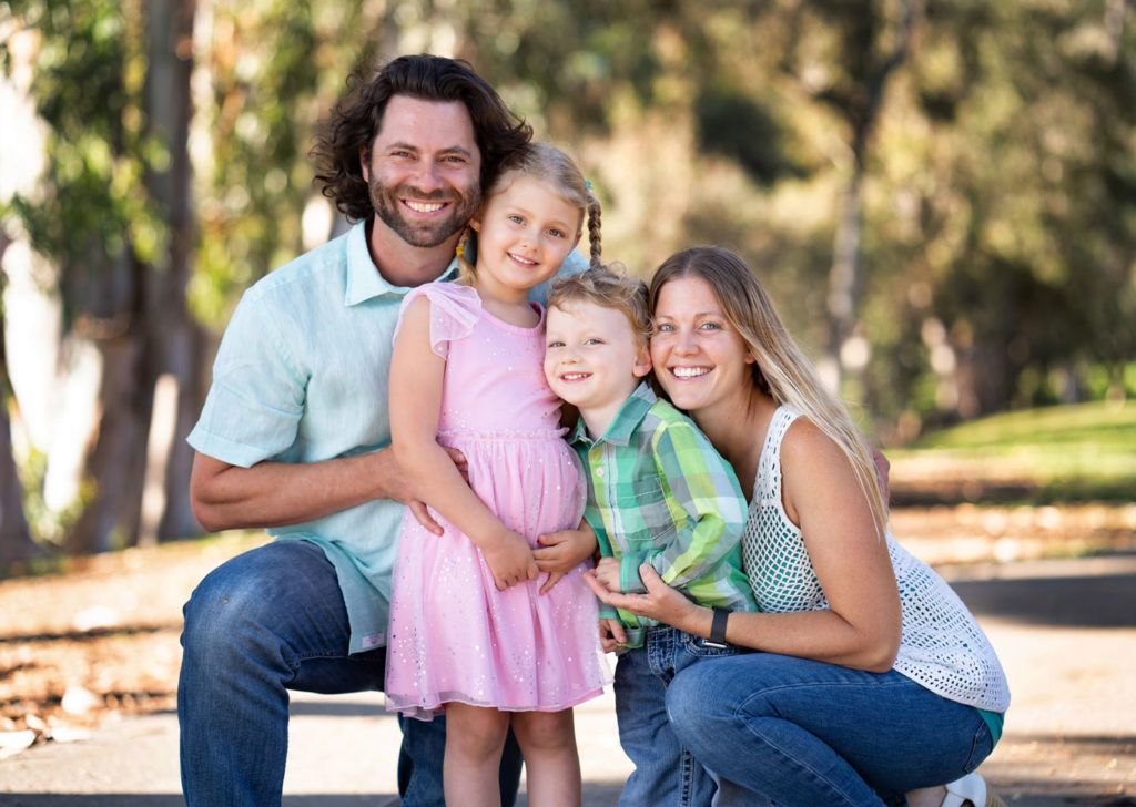 A young family in Huntington Central Park dressed for family photos