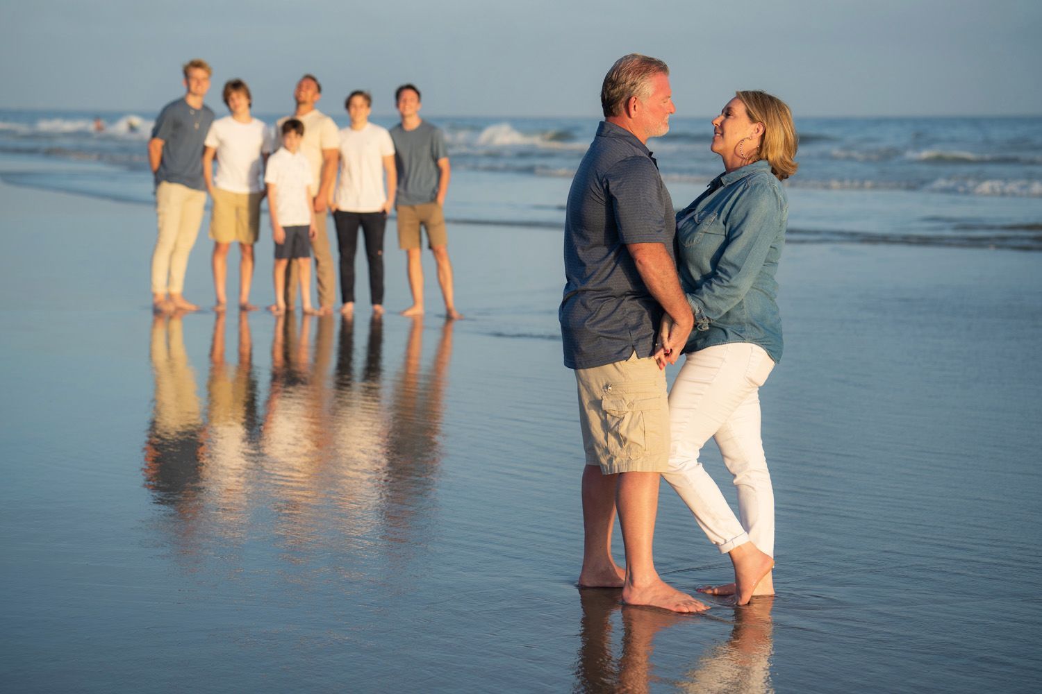 A family is posing for a picture on the beach.