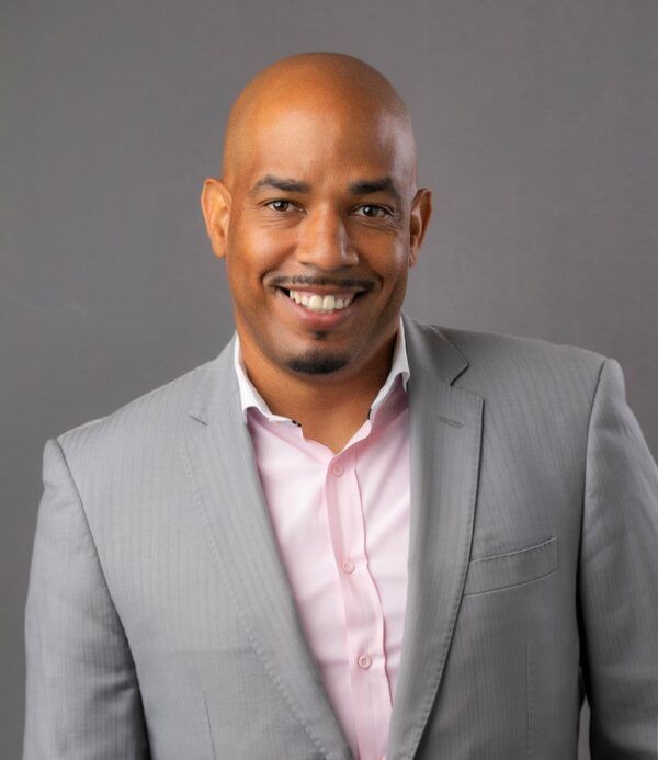 A man in a suit and tie is smiling for the camera.