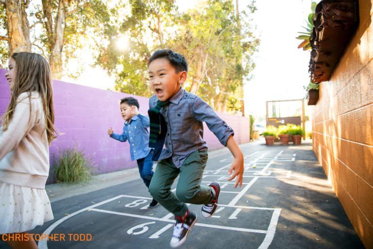 A group of children are playing hopscotch on a sidewalk.