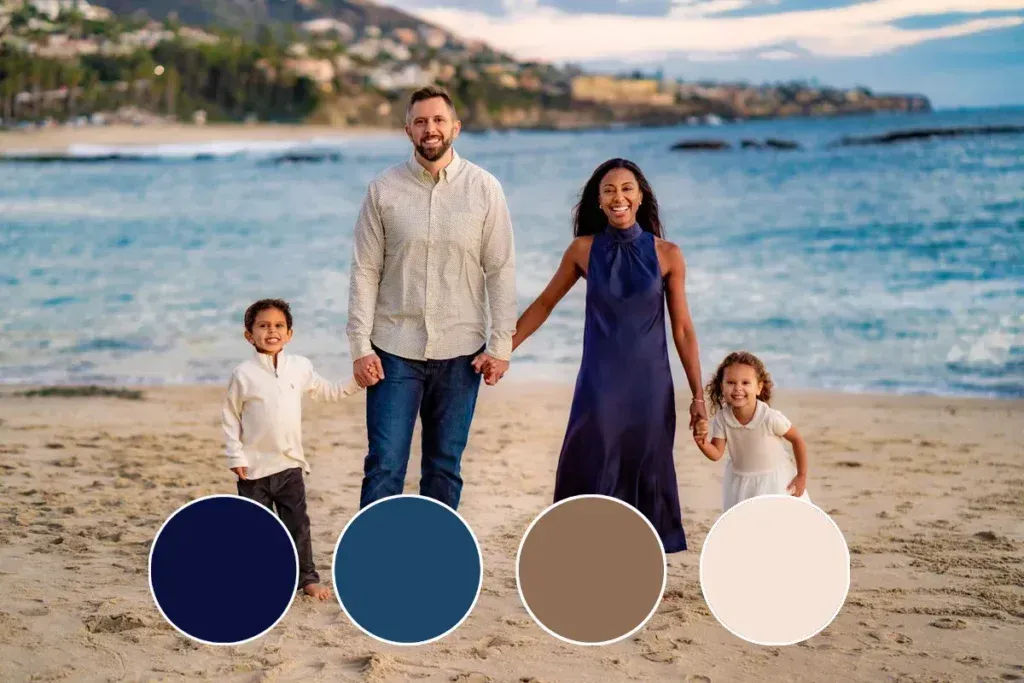 A family is standing on a beach holding hands.