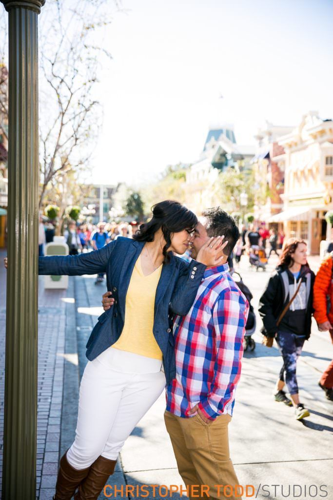 A man and a woman are kissing on Main Street at Disneyland