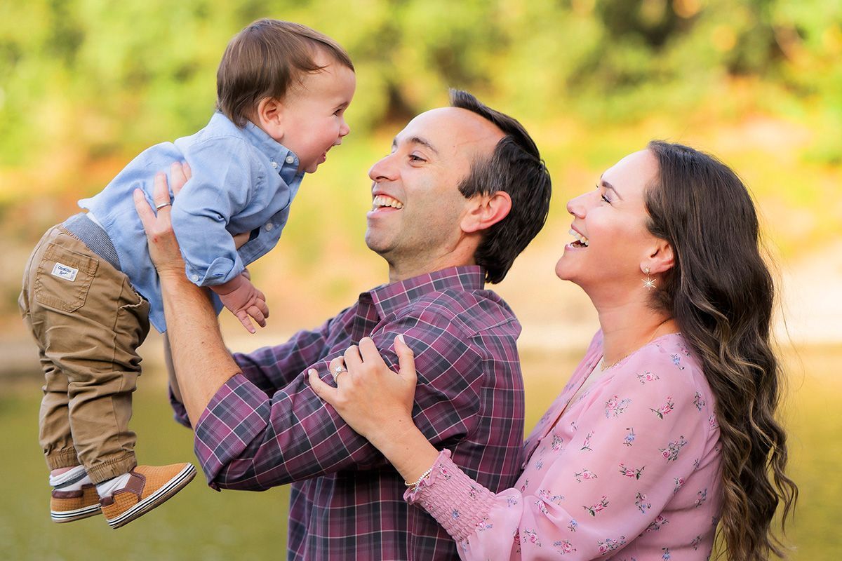 A man and woman are holding a baby in their arms.