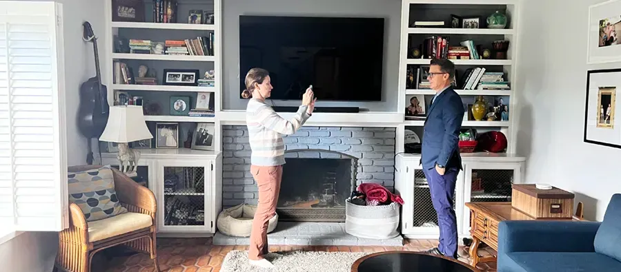 A man and a girl are taking a headshot in a living room 