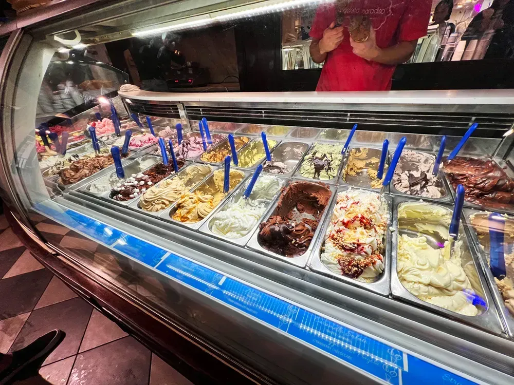 A display case filled with lots of different types of ice cream.