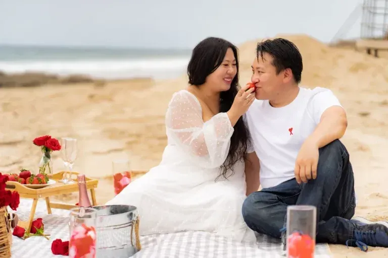 A man and a woman are having a picnic on Crystal Cove beach in Orange County.