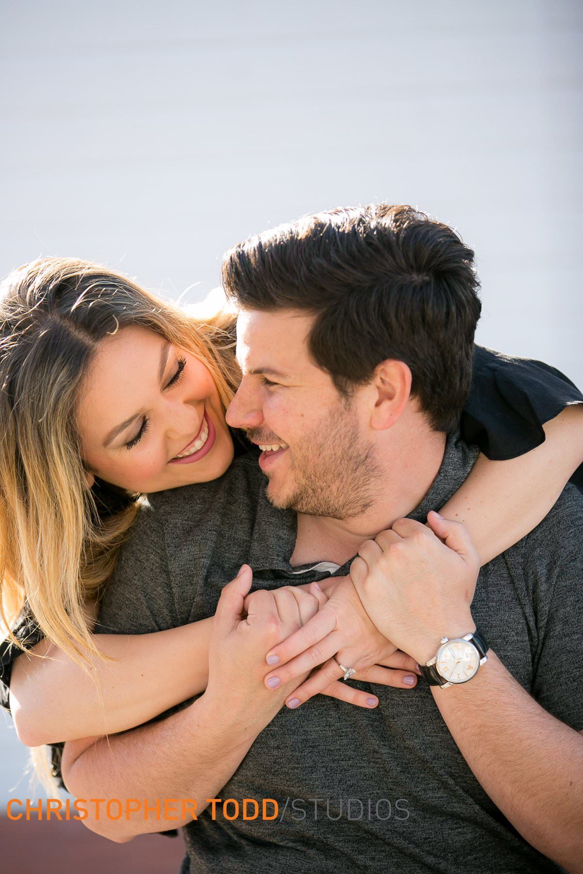 A man and a woman are hugging each other and smiling.