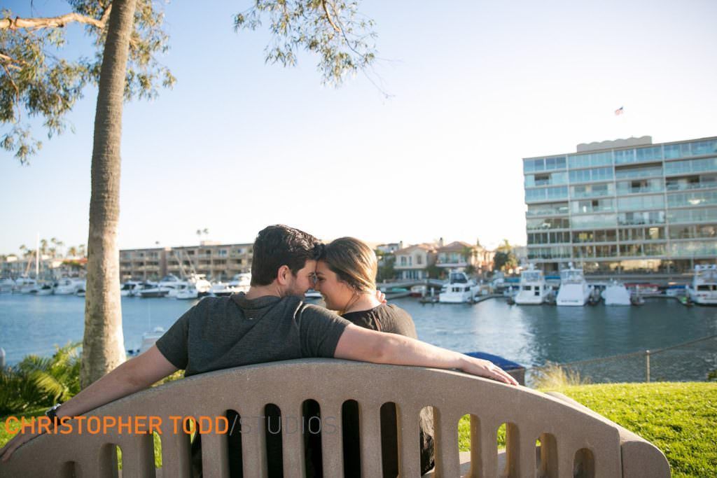 A man and woman are kissing on a bench at Lido Island Bridge