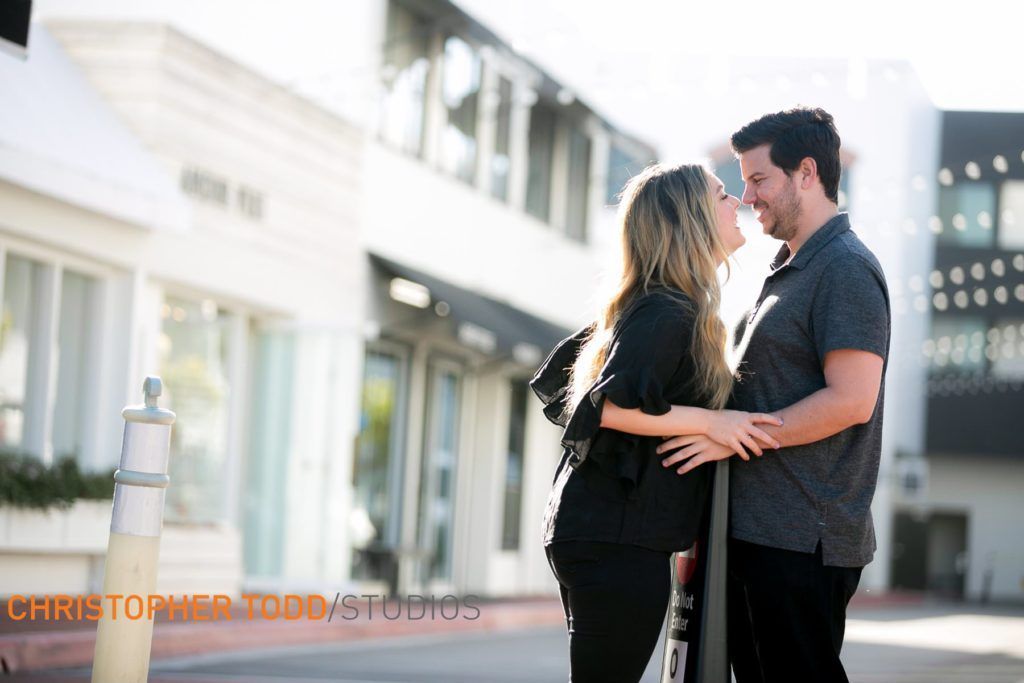 A man and a woman are kissing in front of a building at Lido Marina Village.