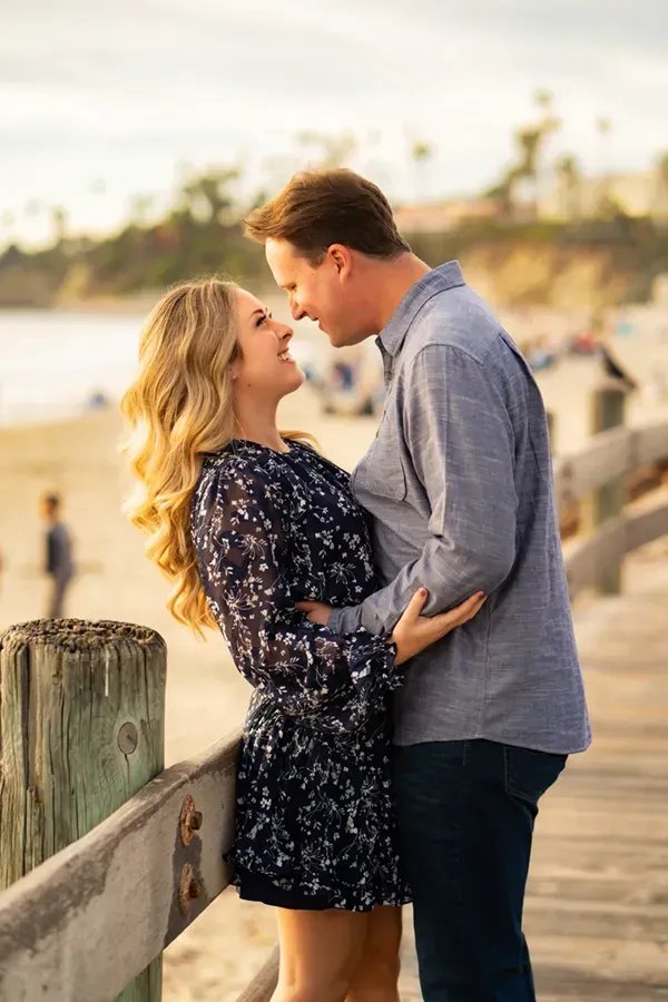A man and a woman are standing next to each other on a pier.