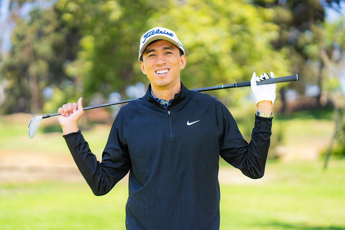 Dating App Profile Photo A man is holding a golf club over his shoulder on a golf course.