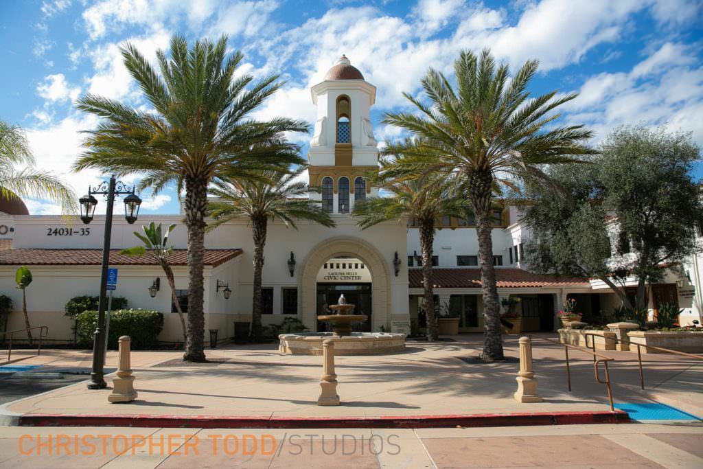 The Laguna Hills CIvic Center with a clock tower and palm trees in front of it