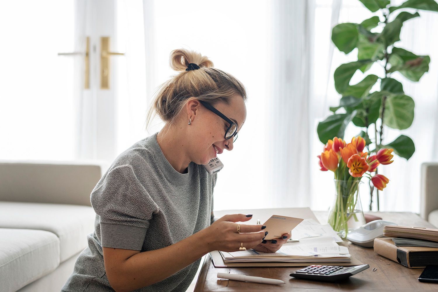 A woman is sitting at a table looking at her phone.