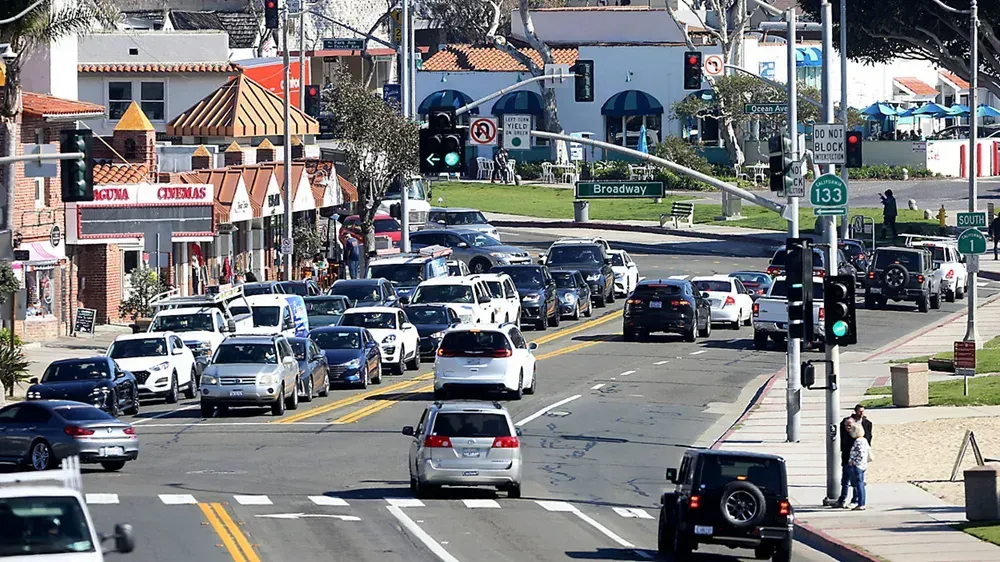 A busy street in Laguna Beach, CA with a lot of cars driving down it