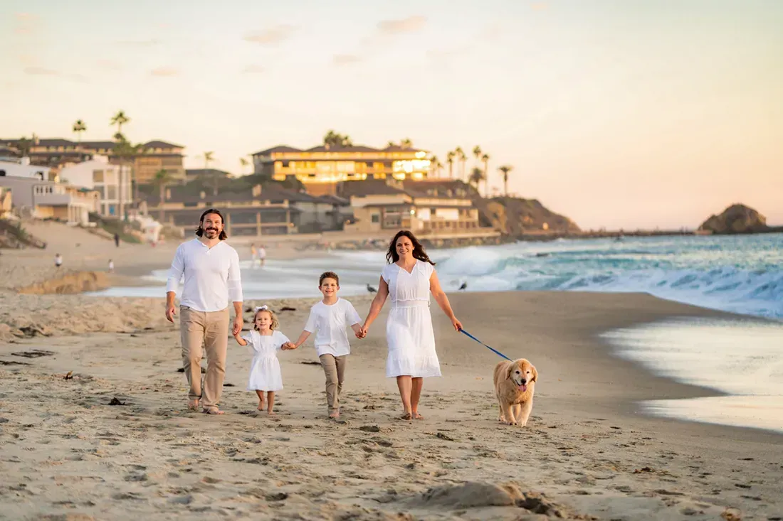 A family is walking their dog on at Victoria beach in Laguna.