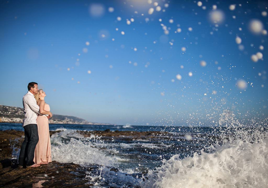 Engagement Photos At Best Beaches In OC An engaged couple is posing for a picture on the beach in Orange County, ca.