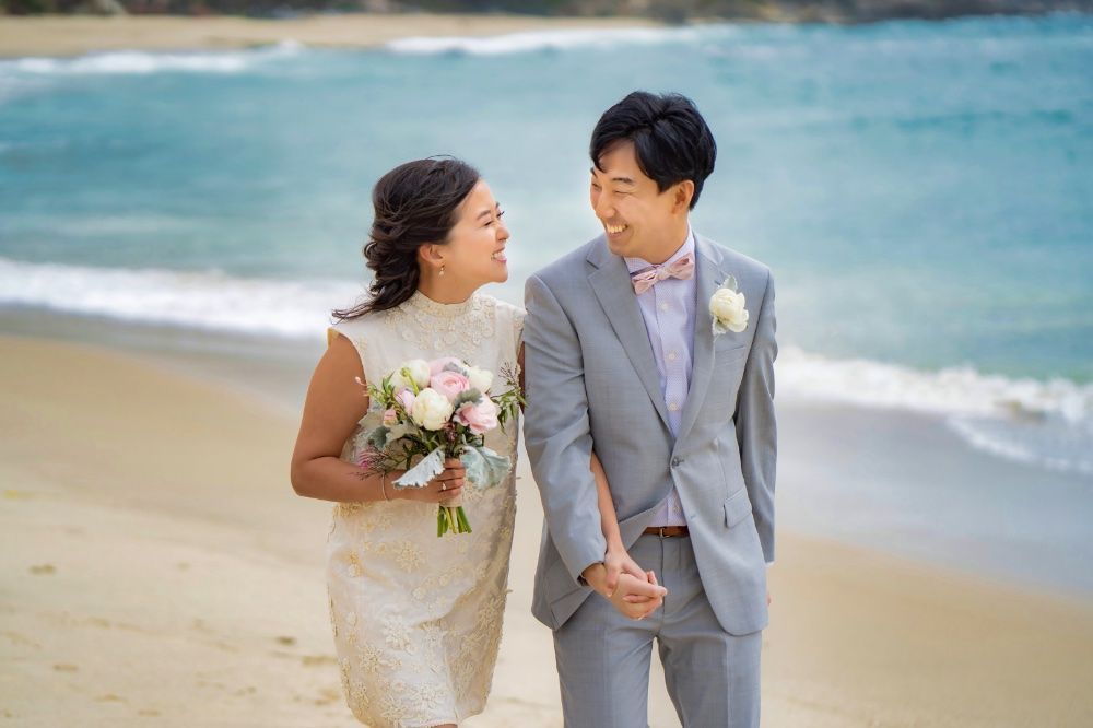 Laguna Beach elopement A bride and groom are walking on the beach holding hands in Laguna, California.