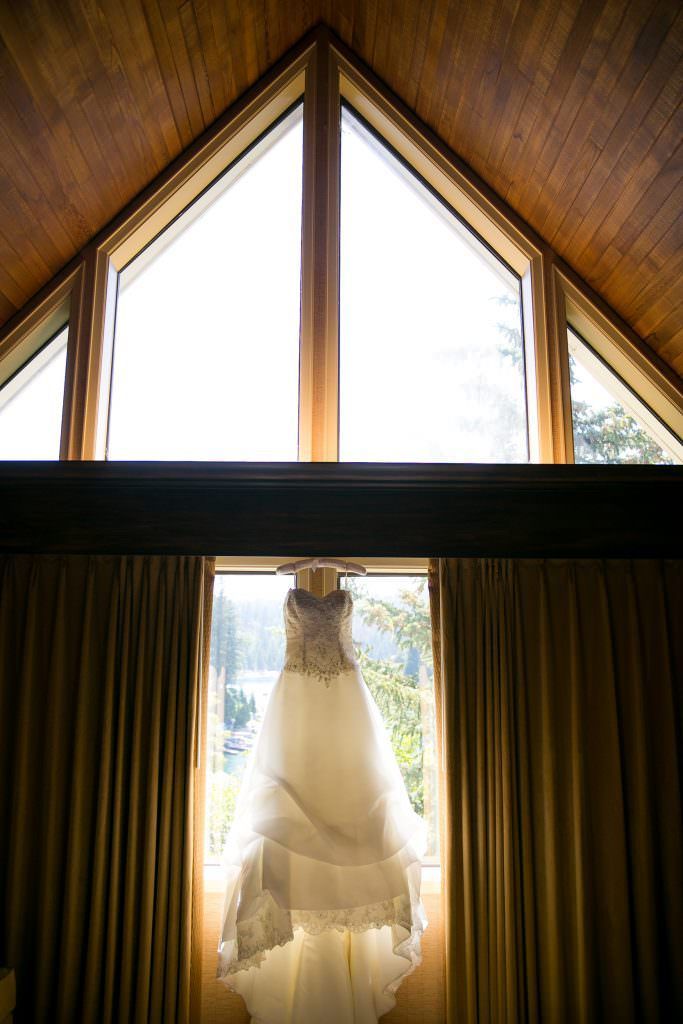 A wedding dress is hanging in a window in a cabin at Lake Arrowhead Resort.