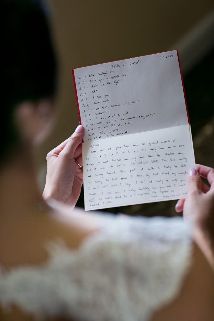 A bride is holding a letter in her hands from her groom.