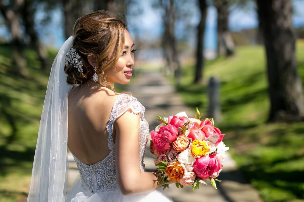 A bride in a wedding dress is holding a bouquet of flowers at the Laguna Cliffs Marriott