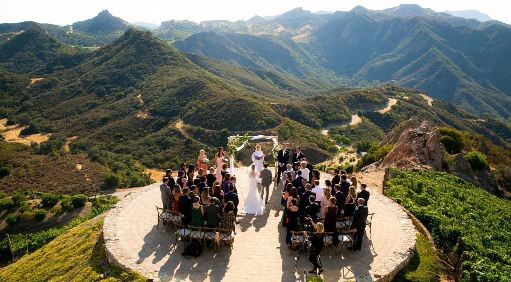 A bride and groom are getting married in on a helicopter pad at Malibu Rocky Oaks
