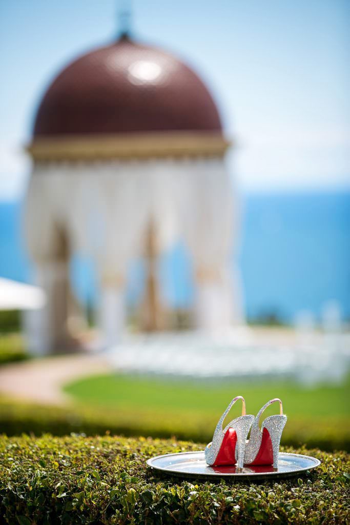 A pair of shoes on a plate with Pelican Hill Rotunda in the background.