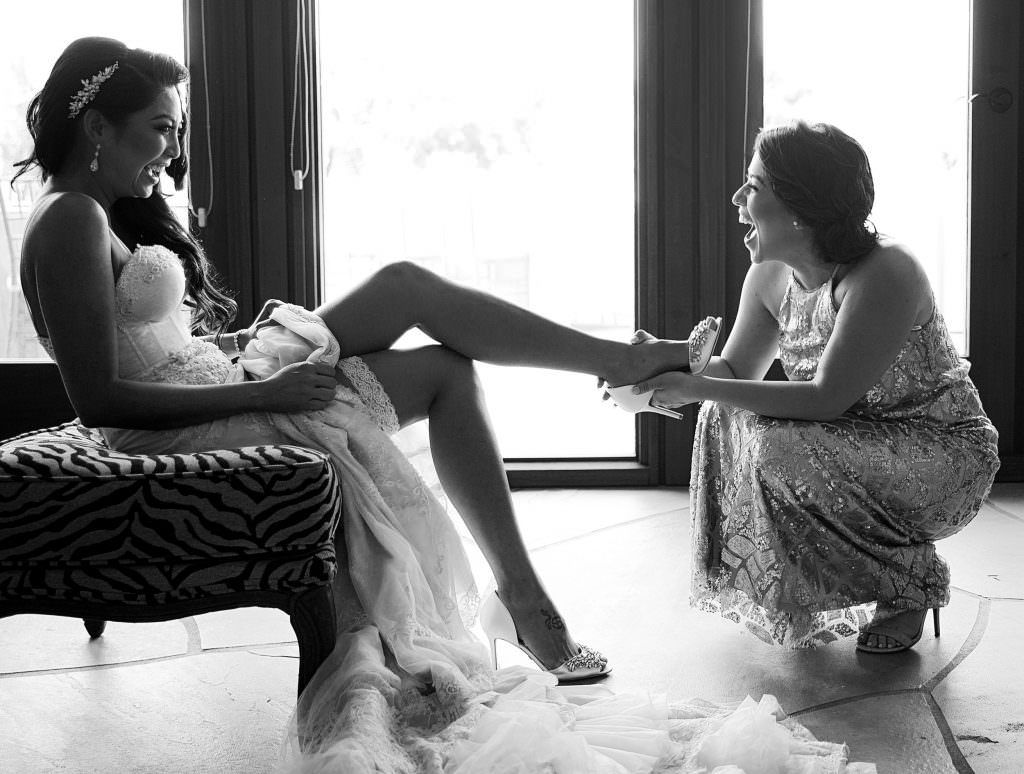 A bridesmaid is helping the bride get ready for her wedding