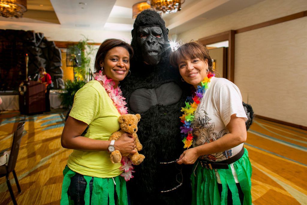Themed Party Photographer Two women are posing for a picture with a gorilla costume.