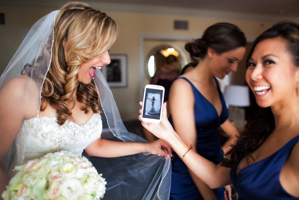 A bride is taking a picture of herself with her bridesmaids at the Waldorf Austoria in Laguna Niguel