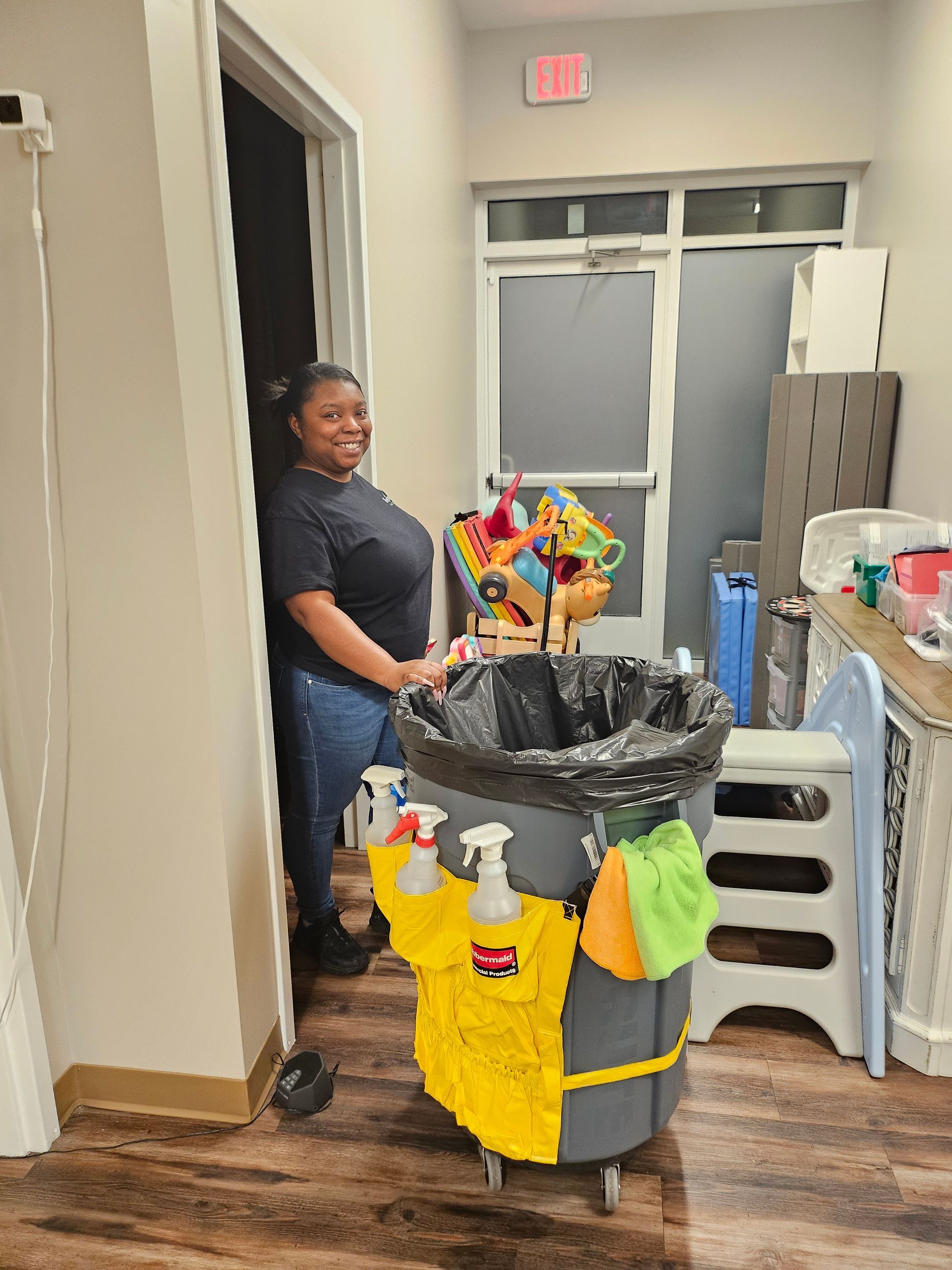 A professional cleaner from Regional Facility Services standing next to a cleaning cart A professional cleaner from Regional Facility Services standing next to a cleaning cart