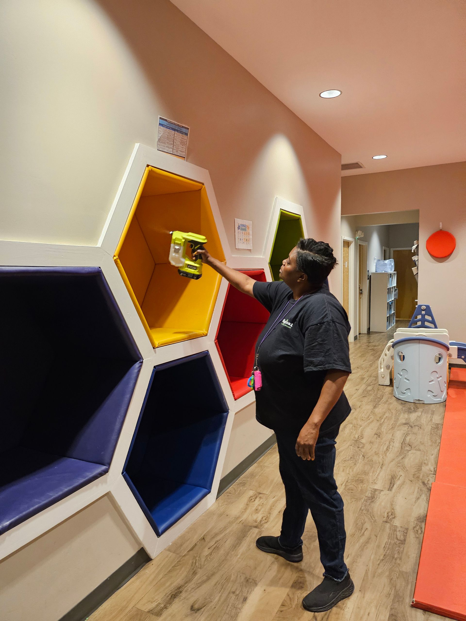 A person cleaning a yellow hexagon-shaped cubby A person cleaning a yellow hexagon-shaped cubby