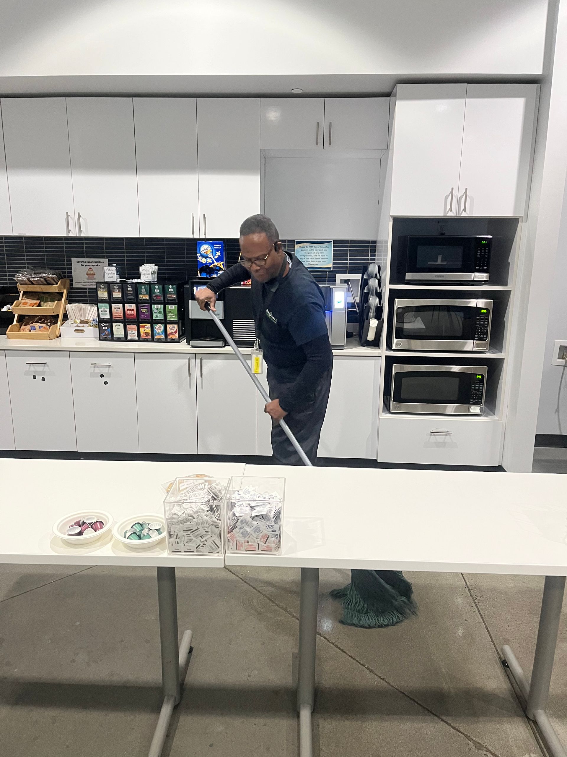 A man mopping the floor in commercial kitchen